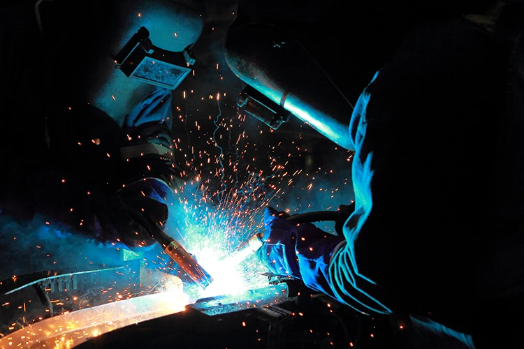 Due operatori di SC Srl saldano lamiere di metallo